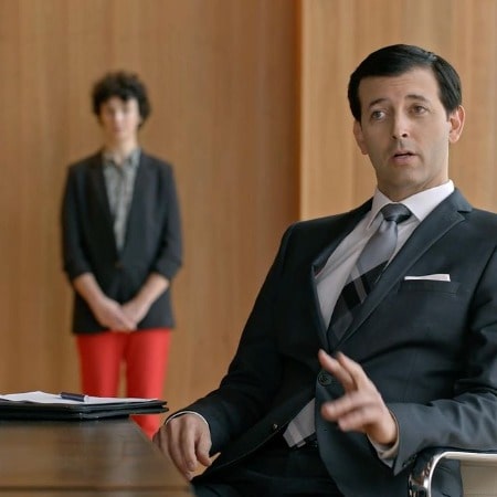 Picture of Jonathan Watton in a back suit in a scene of a series 